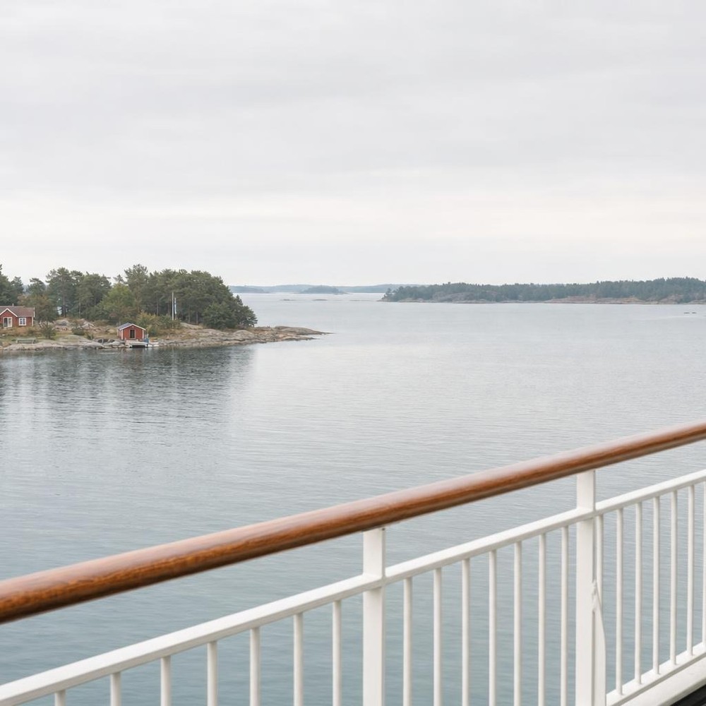 Näkymä laivan kannelta Ruotsin saaristoon, jossa on punaisia mökkejä